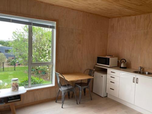 una pequeña cocina con mesa y ventana en Brighton Beach, en Dunedin