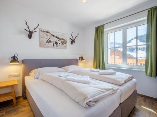 two beds in a room with a large window at Tauernsuites Sonnblick Top 5 in Mühlbach am Hochkönig