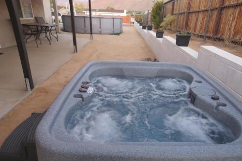 a hot tub sitting on top of a patio at Panoramic Night Lights in Joshua Tree