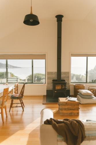 a living room with a fireplace and a stove at Silver Moon at Half Moon in Bicheno