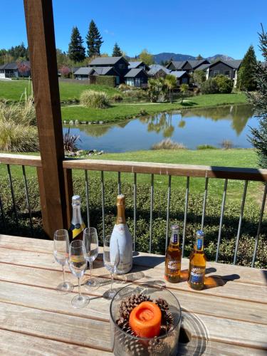 a table with glasses and bottles of beer on a deck at Lake Villa 463 in Hanmer Springs