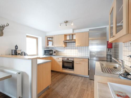 a kitchen with wooden cabinets and stainless steel appliances at Kitzbüheler Alpen XL in Bramberg am Wildkogel