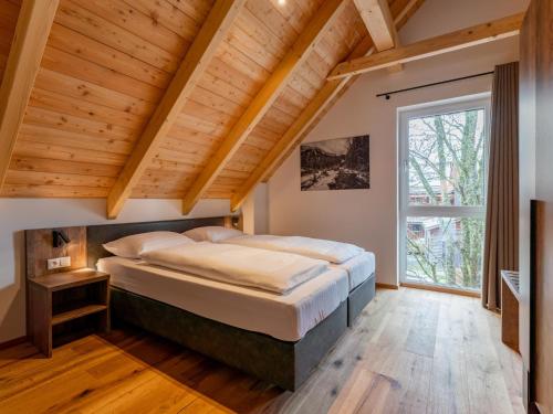 a bedroom with a large bed and wooden ceilings at Mountain Chalet Dahoam in Sankt Lorenzen ob Murau