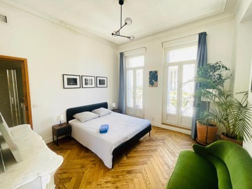 um quarto com uma cama e uma grande janela em Haussmannien lumineux em Marselha