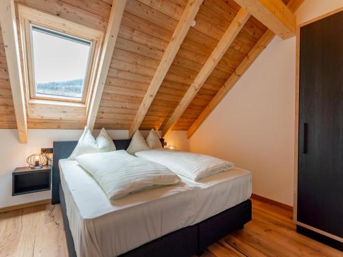 - une chambre avec un grand lit et un plafond en bois dans l'établissement Bergzicht 2A, à Sankt Lorenzen ob Murau