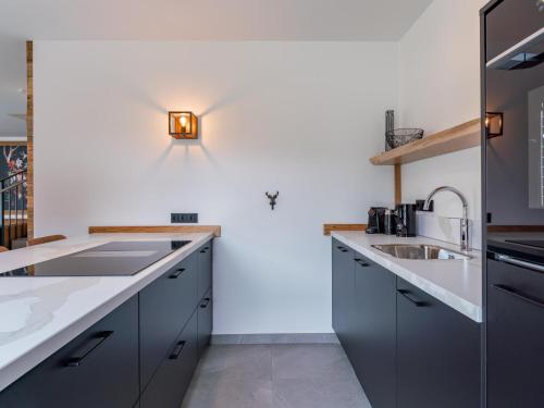 a kitchen with gray cabinets and a white wall at Bergzicht 2A in Sankt Lorenzen ob Murau
