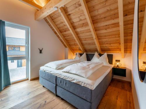 una camera con un grande letto e un soffitto in legno di Bergzicht 2B a Sankt Lorenzen ob Murau
