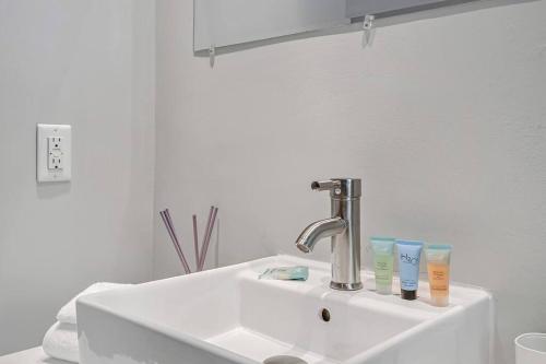 a bathroom sink with a faucet and two cups on it at Charming HBG Haven: Cozy 1BR Apt in Harrisburg