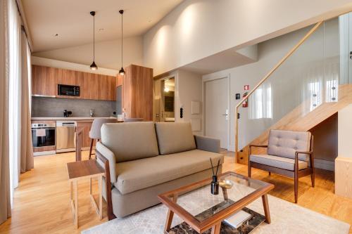 een woonkamer met een bank en een tafel bij AVUS M Suites and Apartments by DA'HOME in Porto