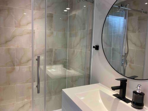 a bathroom with a shower and a sink and a mirror at Grandravine/Beautiful Unit near downtown Toronto in Toronto