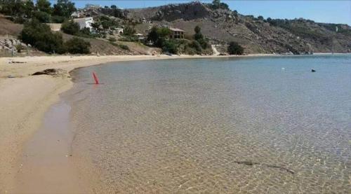 a beach with a red pole in the water at La Foggia seaside paradise in Siculiana