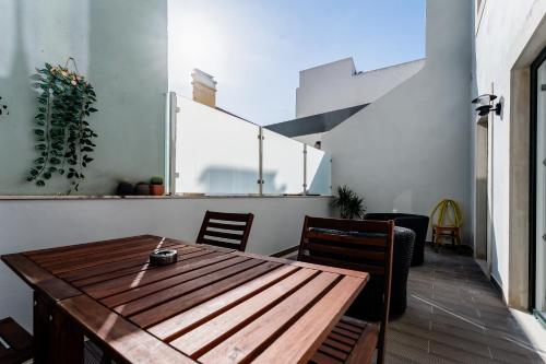 a dining room with a wooden table and chairs at Pátio da Baixa in Setúbal