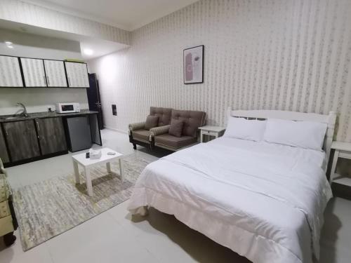 a bedroom with a large white bed and a couch at Studio in Ajman 
