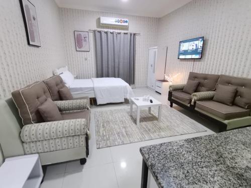 ein Wohnzimmer mit einem Bett, einem Sofa und einem TV in der Unterkunft Studio in Ajman 
