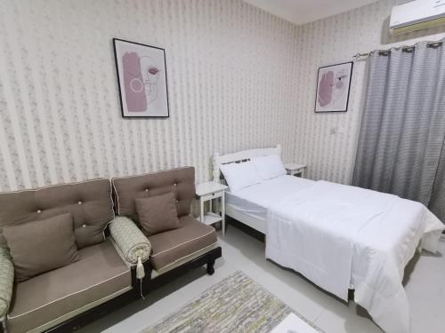 um quarto de hospital com uma cama e um sofá em Studio em Ajman