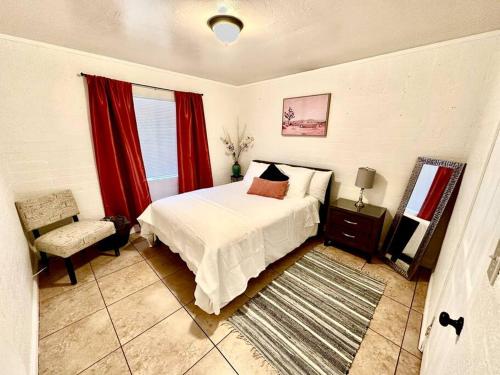 - une chambre avec un lit, une chaise et des rideaux rouges dans l'établissement *Free Parking near Strip Cozy 2Br home Side: A, à Las Vegas