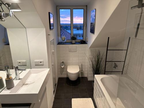 a bathroom with a tub and a toilet and a window at Oasis Appart - Wohnen am Elbtal Dresden - Balkon - Netflix - Tiefgarage in Dresden