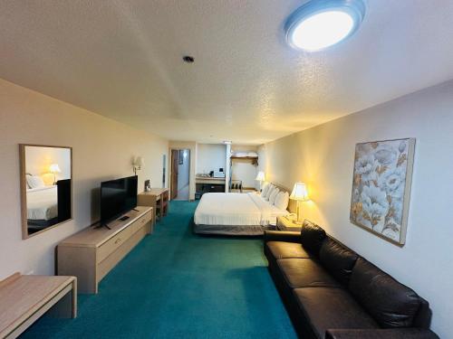 Timberland Inn & Suites في كاسل روك: غرفه فندقيه بسرير واريكه