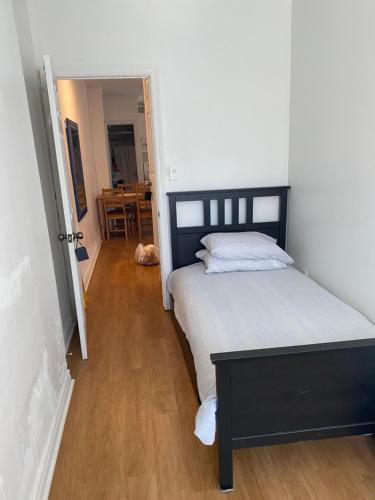 a bedroom with a large bed and a wooden floor at Private Single Room with Shared Bathroom 536C in Toronto