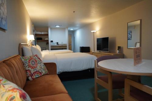 a hotel room with two beds and a couch and a table at Timberland Inn & Suites in Castle Rock