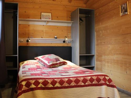 a bedroom with a bed in a room with wooden walls at Gîte Barbas, 2 pièces, 2 personnes - FR-1-584-16 