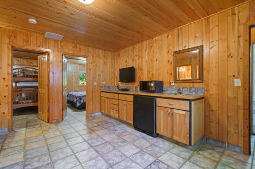 a room with a kitchen with wooden walls and a television at Captain's Hideaway in Nehalem
