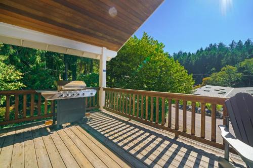a porch with a grill on a wooden deck at Captain's Hideaway in Nehalem