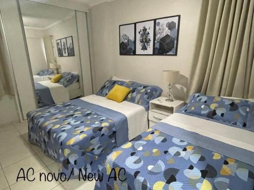 um quarto com 2 camas e um espelho em Rhodes I a Beira-mar da Jatiuca/Ponta Verde em Maceió