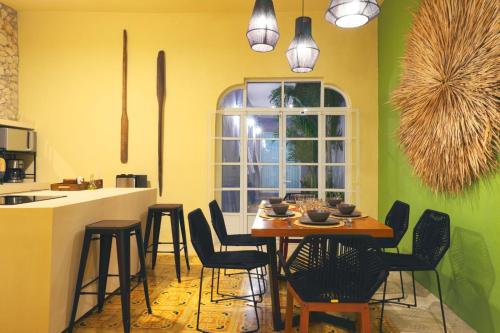 una cucina con tavolo, sedie e finestra di Casa Violeta a Mérida