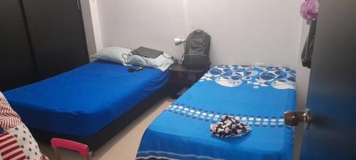 1 dormitorio con 2 camas y edredón azul en Torres de Canarias, en Santa Marta