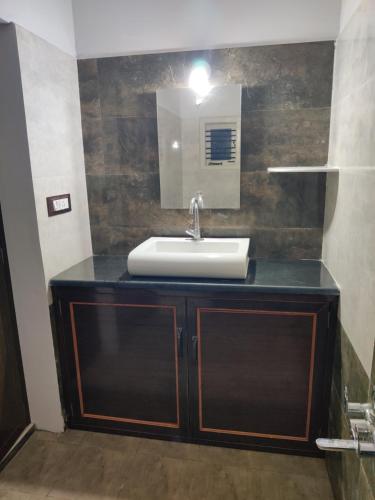 a bathroom with a sink and a mirror at Galaxy Villa's Homestay 8431o31389 in Mysore