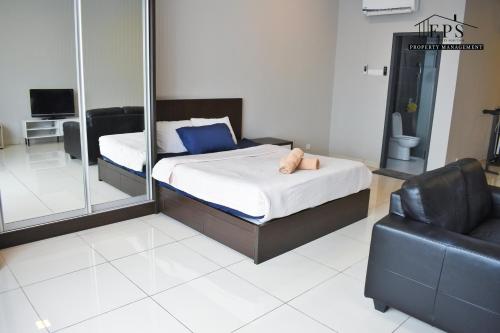 a bedroom with a bed and a chair and a mirror at DaMen Homestay @SubangHomeStay in Subang Jaya