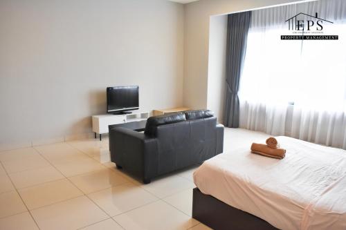 a bedroom with a couch and a tv and a bed at DaMen Homestay @SubangHomeStay in Subang Jaya