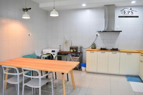 a kitchen with a wooden table and white cabinets at DaMen Homestay @SubangHomeStay in Subang Jaya