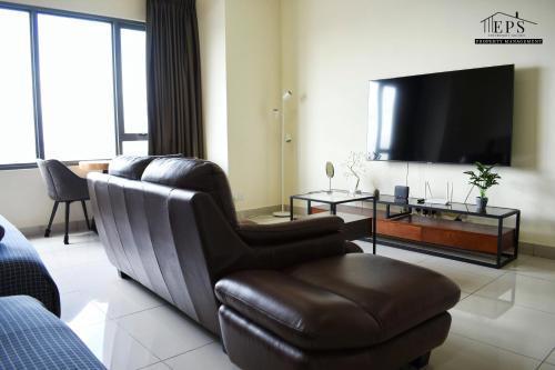a living room with a couch and a flat screen tv at DaMen Homestay @SubangHomeStay in Subang Jaya