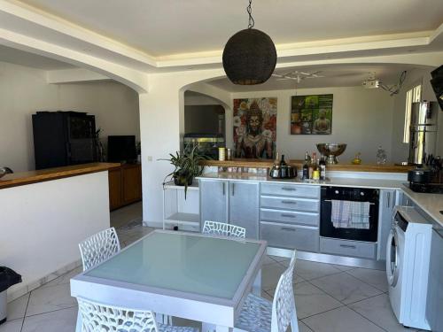 a kitchen with a table and chairs in a kitchen at VILLA 3 GRANDE CHAMBRES 4 étoiles in Sainte-Anne
