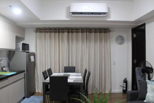 Il comprend une cuisine et une salle à manger avec une table et des chaises. dans l'établissement Abreeza 1BR condo w/ balcony,wifi & Netflix, à Davao