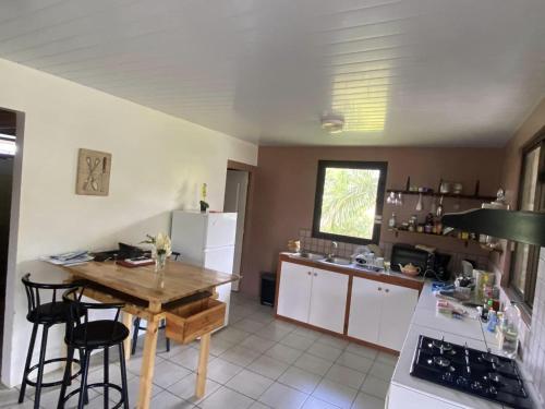 a kitchen with a wooden table and a kitchen with a refrigerator at TAHITI - Bungalow Toah Hoe in Taravao