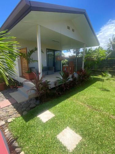 une maison avec une cour d'herbe devant elle dans l'établissement TAHITI - Bungalow Toah Toru, à Taravao