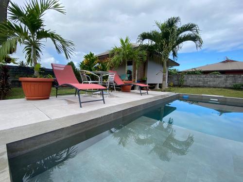 Taravao的住宿－TAHITI - Bungalow Toah Toru，房屋旁的游泳池配有桌椅