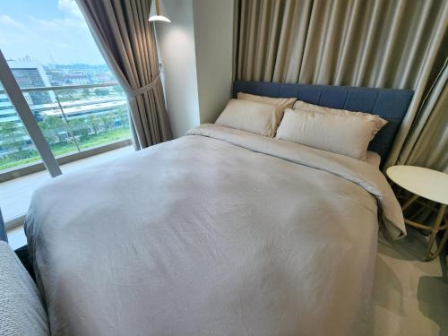 a bedroom with a large bed with a large window at Kuching Town DeSunset - Balcony with Amazing View in Kuching
