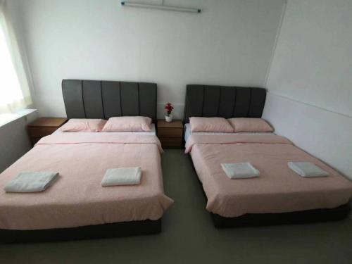 two beds sitting next to each other in a room at Moonriver Lodge in Cameron Highlands