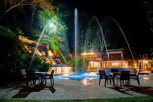 a table and chairs in front of a fountain at night at Bio Rio Hotel in San Jerónimo