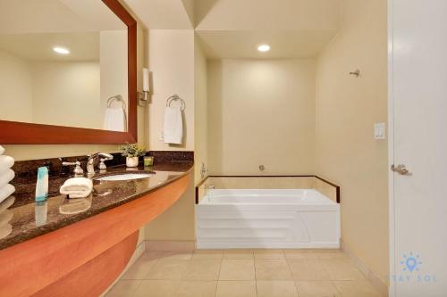 La salle de bains est pourvue d'une baignoire, d'un lavabo et d'un miroir. dans l'établissement Luxurious Beach Resort Balcony, à Sunny Isles Beach