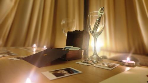 a table with a wine glass and a candle on it at Glamping Dunas del sol in San Pedro de Atacama