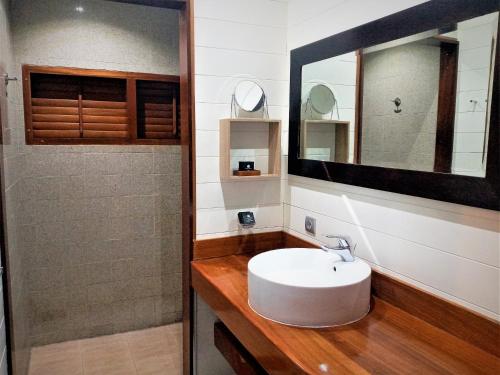 y baño con lavabo blanco y espejo. en MOOREA - Villa Ana Mua, en Papetoai