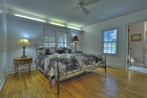 a bedroom with a bed and a table and windows at Mccaysville River House in McCaysville