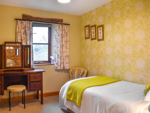 um quarto com uma cama, uma cómoda e uma janela em Barn End em Pooley Bridge
