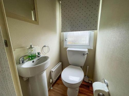 małą łazienkę z toaletą i umywalką w obiekcie Brilliant Caravan With Wifi And Decking Near Pakefield Beach Ref 68040cr w mieście Lowestoft