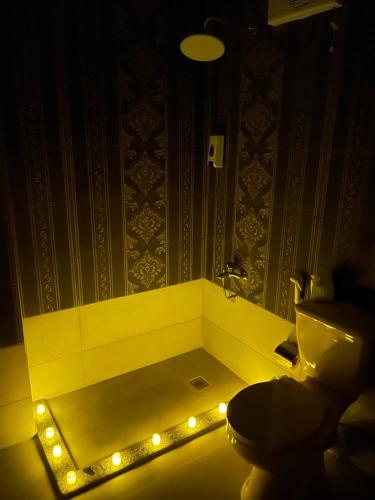 a bathroom with a toilet with lights on it at Locanda Pyramids Hotel in Cairo